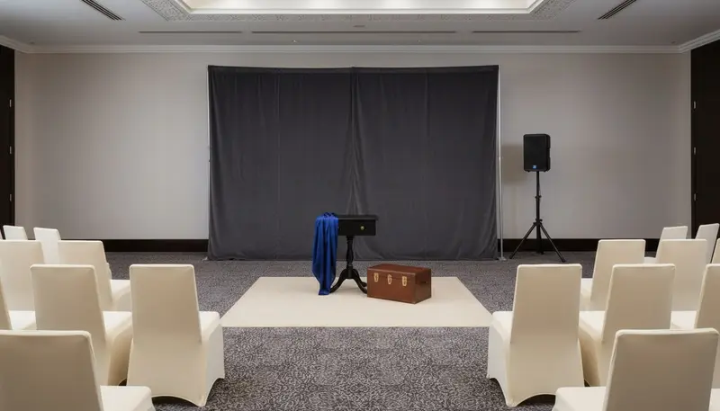 Empty performance space set up for a magic show in a Dubai function room before guests arrive
