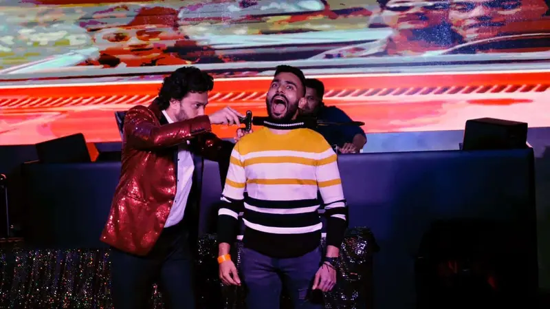 Stage magician performing an illusion with a volunteer from the audience